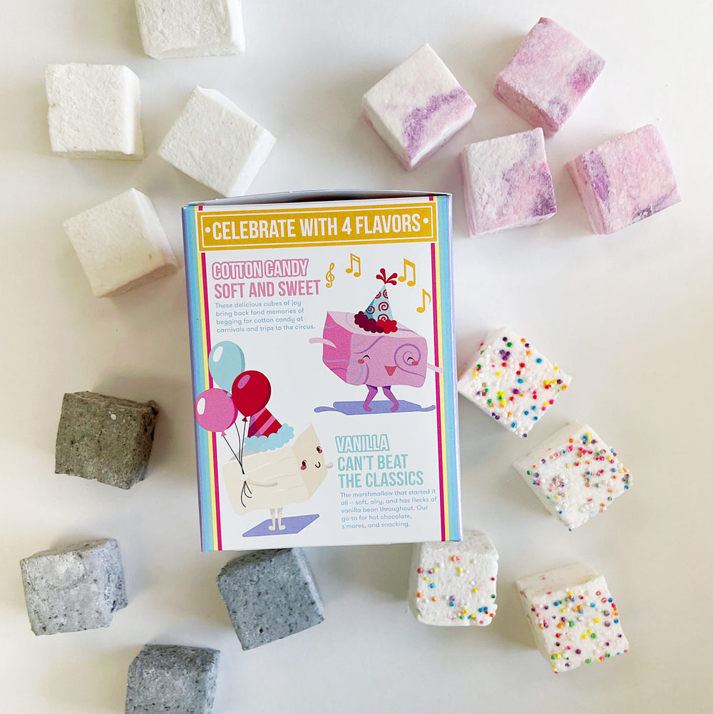 Vanilla, Cotton Candy, Cookies and Cream, and Funfetti marshmallows surround the packaging for their Birthday Wishes Variety Pack. This side features an illustration of a cotton candy marshmallow with a party hat & dancing and a vanilla marshmallow with balloons.