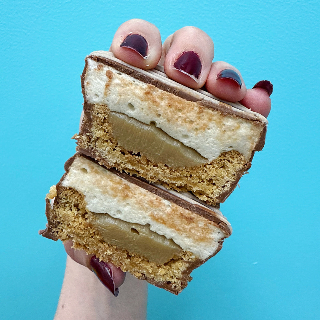 A cross section of our fluffernutter treats showing the inside cookie, ganache, mallow and milk chocolate layer. Looks like a peanut butter cup without the peanut butter!