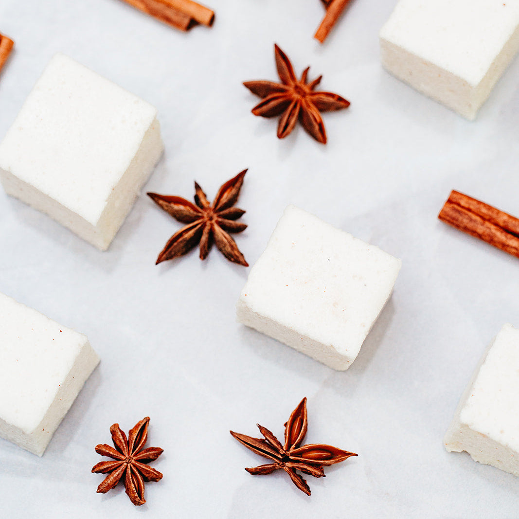 Maple Cinnamon Marshmallows, arranged on a light marble-like surface with cinnamon sticks and star anise.