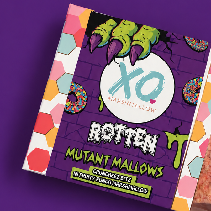 A box of XO Marshmallows Rotten Mutant Marshmallows, featuring a purple and multicolor graphic label with a clear window showing the pinkish-brown marshmallows inside, set against a solid purple background.