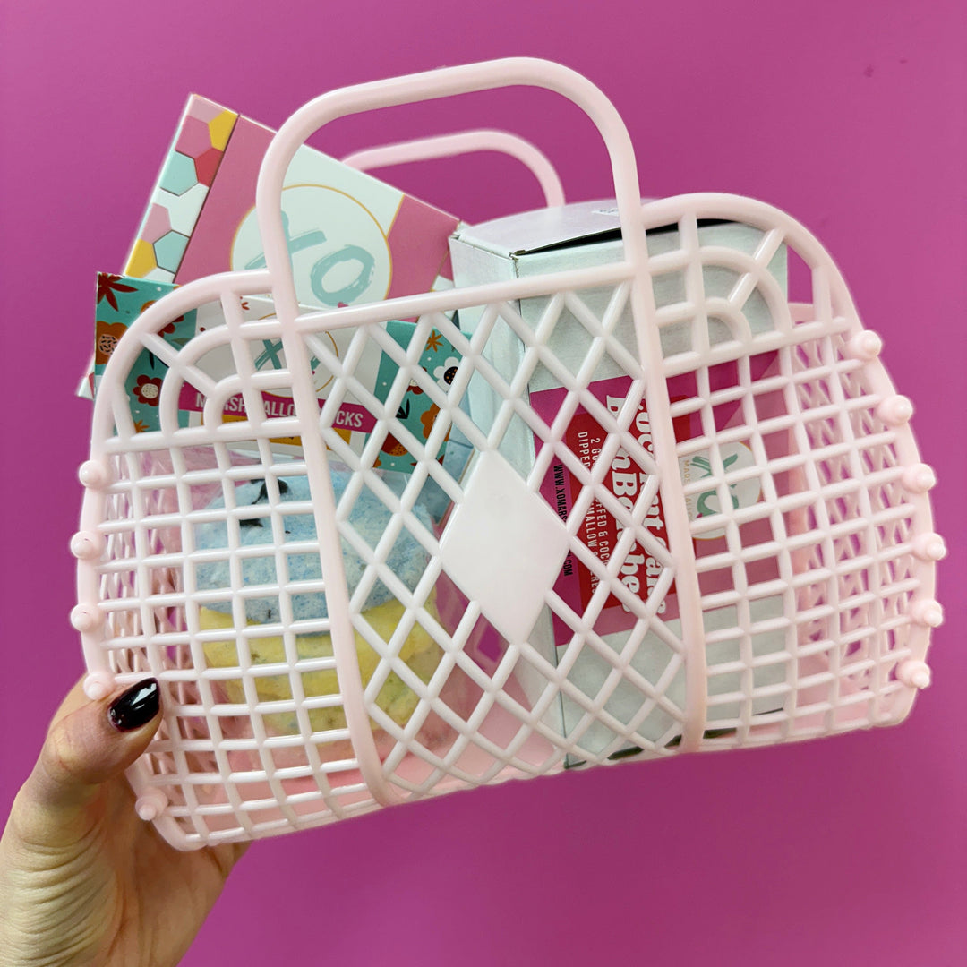 a pink purse shaped basket filled with marshmallow chicks, coconut cake bonbombes, and sour blue raspberry marshmallows