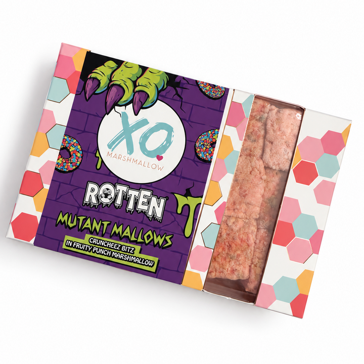 A packaged snack product labeled 'Rotten Mutant Marshmallows' by XO Marshmallows, shown in a tilted rectangular box with a purple front label, colorful hexagonal side pattern, and a clear window revealing pinkish-brown marshmallows inside, on a white background.