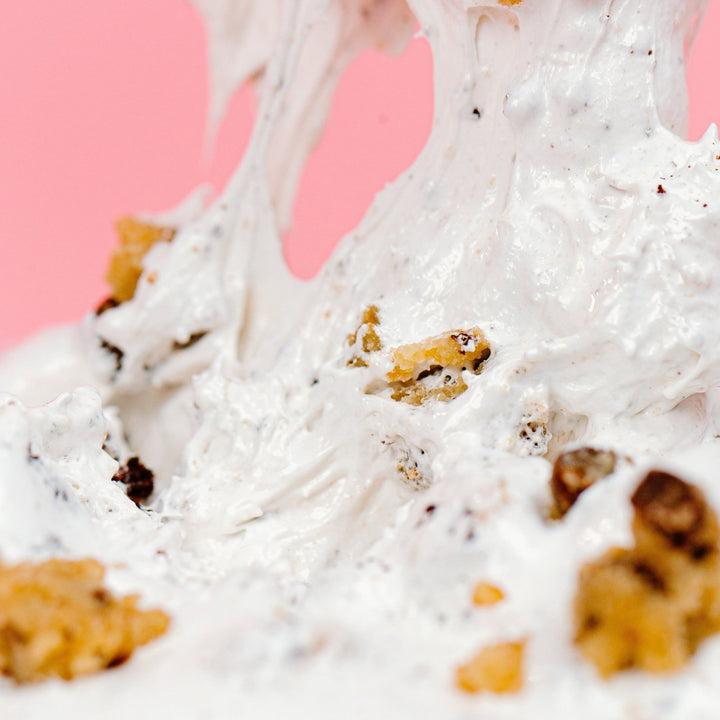 A really zoomed in shot of the Brookie Dough OMG showing how thick and stretchy it is with pieces of edible chocolate chip cookie dough and brownie mixed throughout