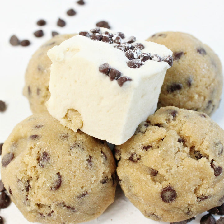 a cookie dough flavored marshmallow topped with chocolate chips sitting on top of scoops of cookie dough